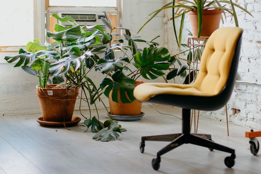 Ein gelber Bürostuhl steht ungenutzt im Büro. Stehen im Homeoffice wird immer beliebter.